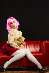 childlike woman and teddy bear sitting on couch