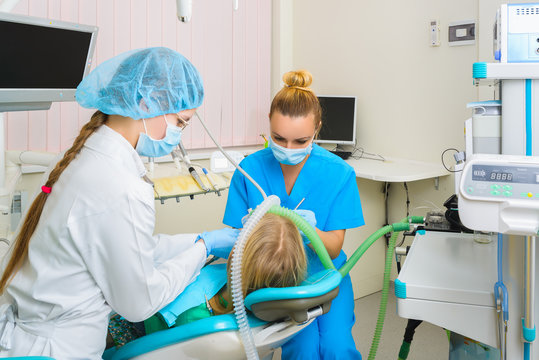 Dentist Performs A Procedure Of Care For Teeth Child With Deep Anesthesia