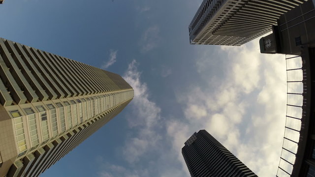 Roof view hyperlapse through the metropolitan skyscrapers in blue skies.