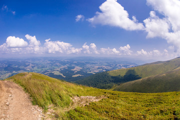 Road on grass on the hill on mountain background