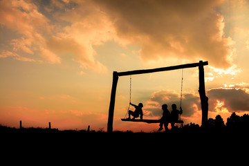 Three young children on a swing