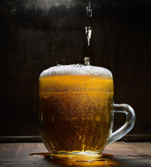 Vintage glass of beer with foam on a wooden board
