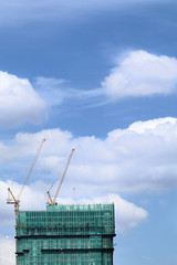 Building under construction with construction cranes
