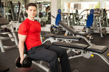 Fototapeta na wymiar Hispanic man lifting weights at the gym