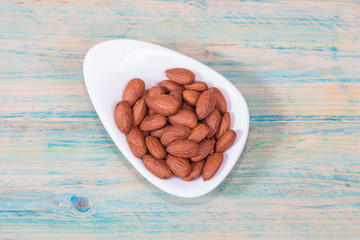 Almonds in bowl on wood