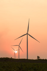 Fototapeta premium silhouette of wind turbines at sunset