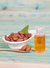 Almonds on wood and oil bottle