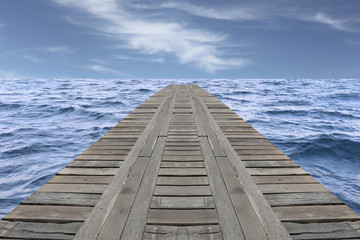 Old wooden bridge in the sea and have slight wave.