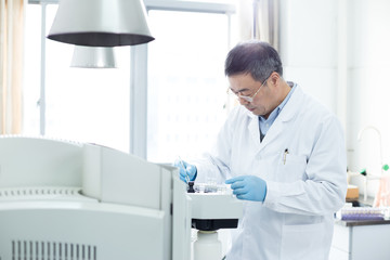 Naklejka premium old man does medical experiment in lab
