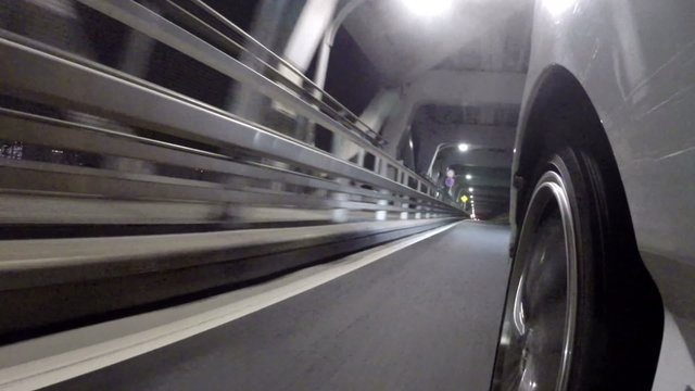 Front wheel variation of a car running through the nightscape of Tokyo and Rainbow Bridge.