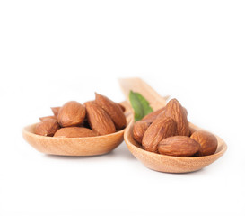 almonds in wood spoon on white background