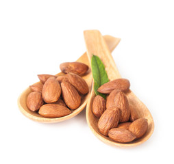 almonds in wood spoon on white background