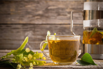 cup of tea with linden on wooden background