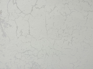 Texture of old shabby weathered white paint on the wall.