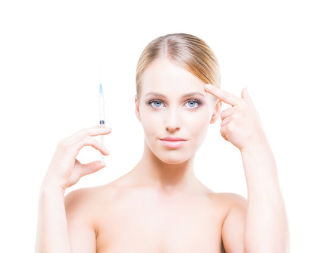 Young woman holding a syringe in her hands and injecting botox into smooth skin.