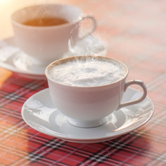 Hot coffee, hot tea on a patterned surface.