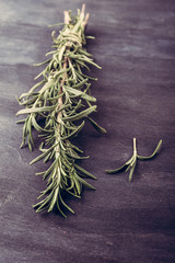 fresh rosemary bunch  on a dark wooden table