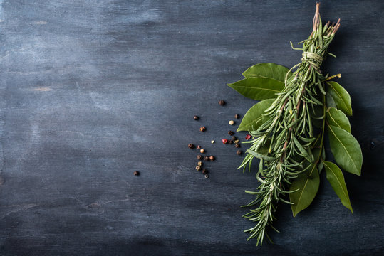  rosemary and laurel leaves  on a dark wooden background