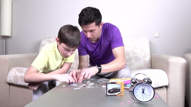 Father and child make puzzle