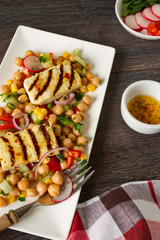 Chickpea salad with raw vegetables and grilled tofu cheese