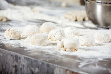 Fototapeta na wymiar Dough Balls Covered With Flour On Table