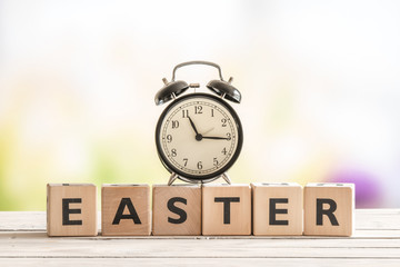 Alarm clock on a wooden easter sign