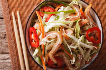 pork ears salad with vegetables close-up on the table. horizontal top view
