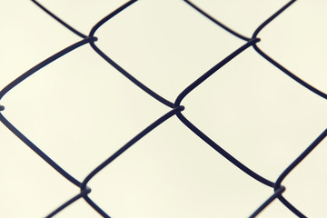 close up of mesh fence over gray sky