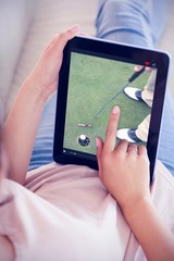 Composite image of girl using her tablet on the couch