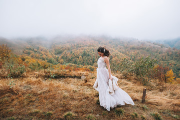 Beautiful bride posing in high mountain scenery