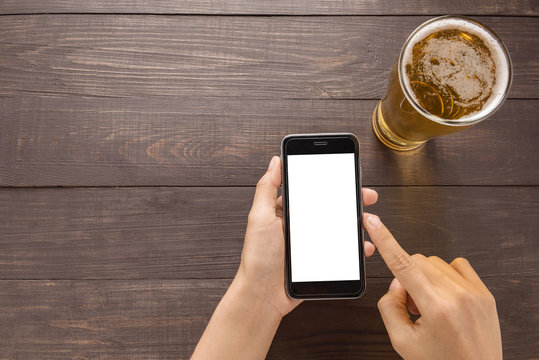 Using smartphone beside of beer in the pub