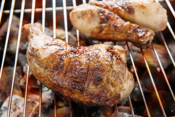 Grilled chicken thigh over flames on a barbecue
