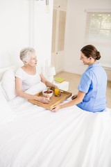 Obraz na płótnie Canvas Nurse taking care of suffering senior patient 