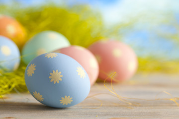 Colored Easter eggs in pastel colors on green and blue backgroun