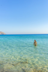 Fototapeta na wymiar Girl walking in the water, on one of the most beautiful beaches