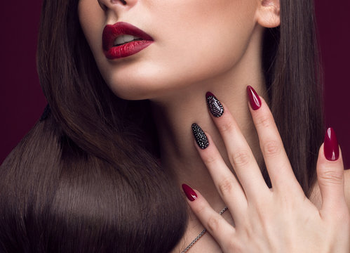 Pretty girl with unusual hairstyle, bright makeup, red lips and manicure design. Beauty face. Art nails.