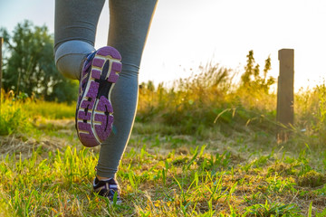 Woman running at sunset in a field