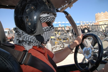a man wearing a helmet, goggles, scarf and holding on to the ste