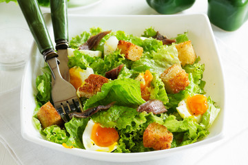 Salad with croutons, anchovies and eggs.