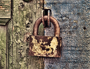 Old metal lock on wooden door taken closeup.Toned image.