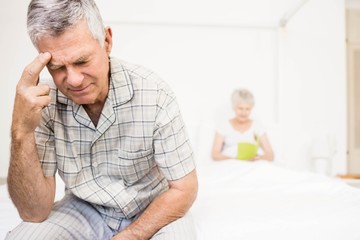 Suffering senior man touching his forehead