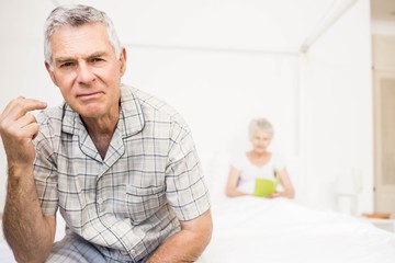 Suffering senior man touching his forehead