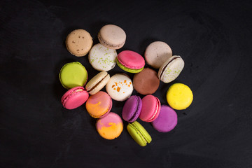 Assorted colorful macaroons on a dark background