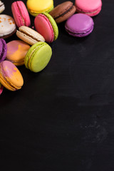 Assorted colorful macaroons on a dark background