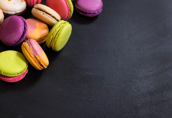 Assorted colorful macaroons on a dark background