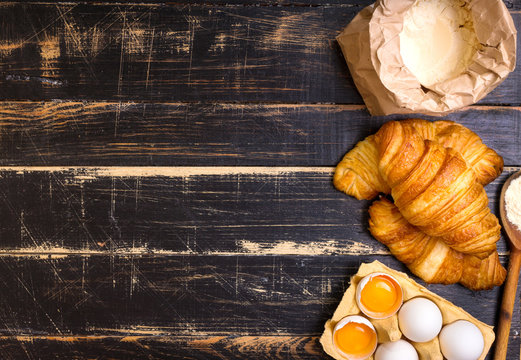 Croissants, flour, eggs, spoon background