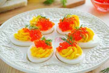 Eggs stuffed with creamy mousse and red caviar.