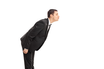 Young groom leaning to kiss someone