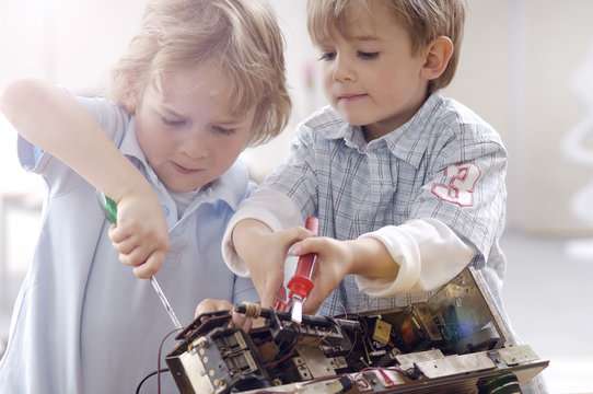 Two little boys disassembling an old radio