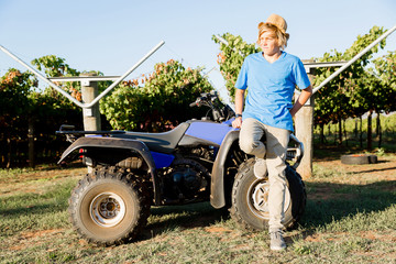 Boy standing next to truck in vineyard